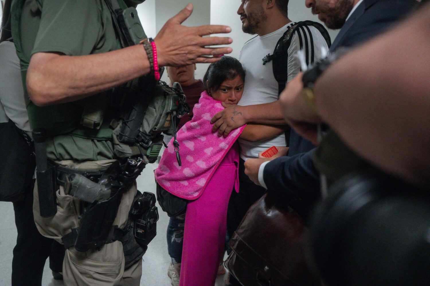 An asylum seeker from Ecuador hugs her father as he is detained by federal agents, Thursday, July 3...