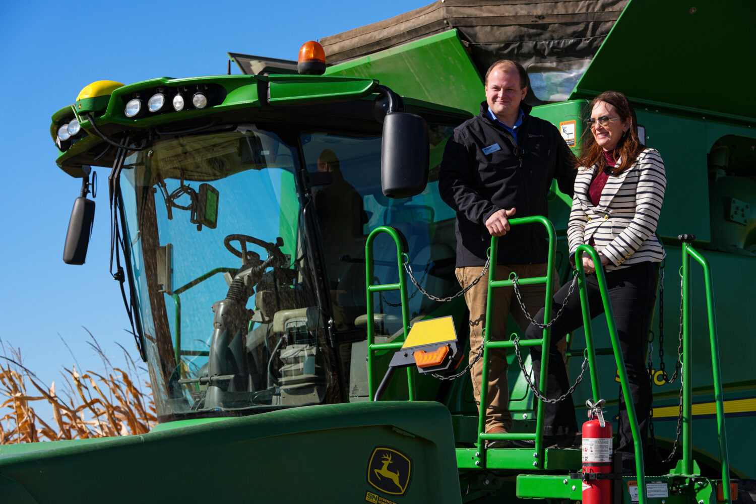 U.S. Secretary of Agriculture Brooke L. Rollins, right, films a social media post on a combine with...