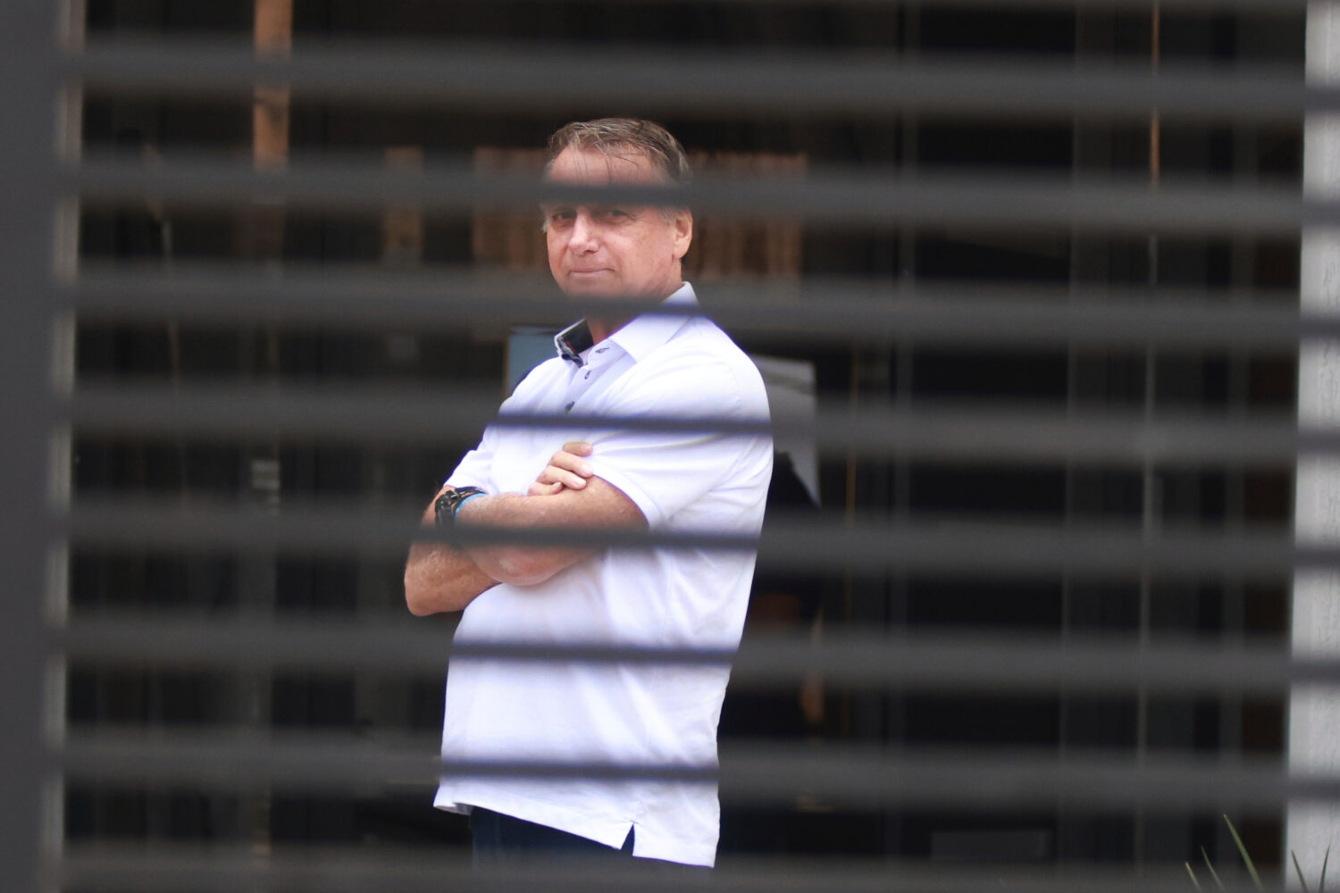 FILE - Brazil's former President Jair Bolsonaro stands at the entrance of his home where he is unde...