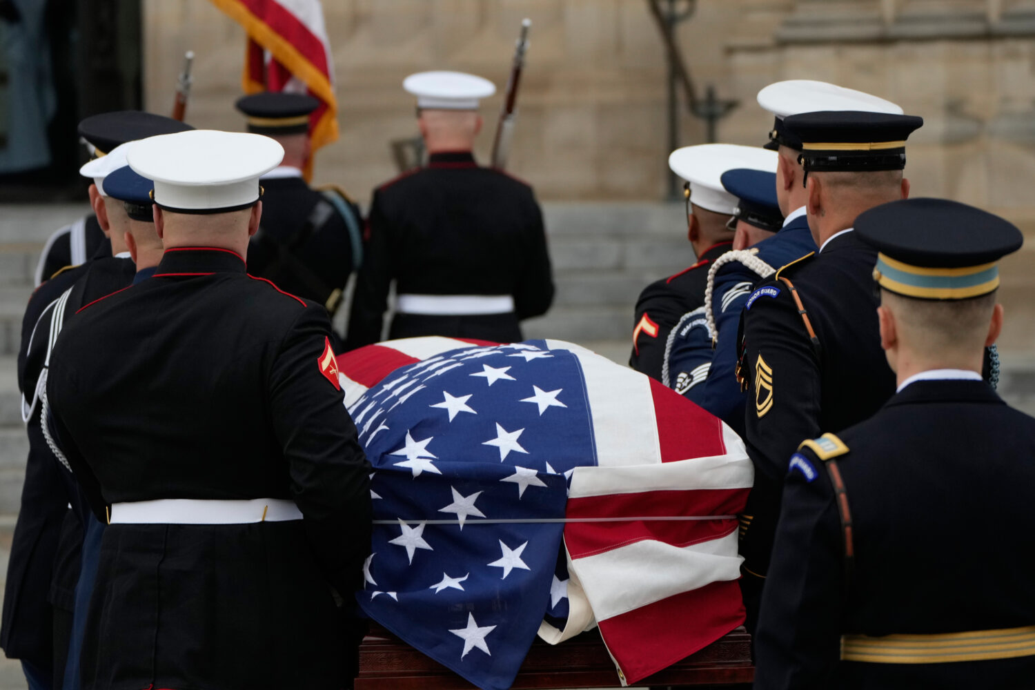 A joint services body bearer team carries the flag-draped casket of former Vice President Dick Chen...