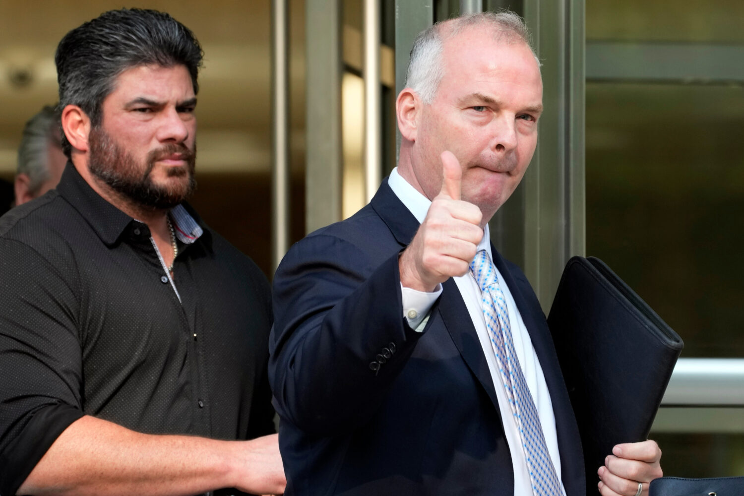 FILE - Michael McMahon, right, gives photographers a thumbs up as he leaves federal court, May 31, ...