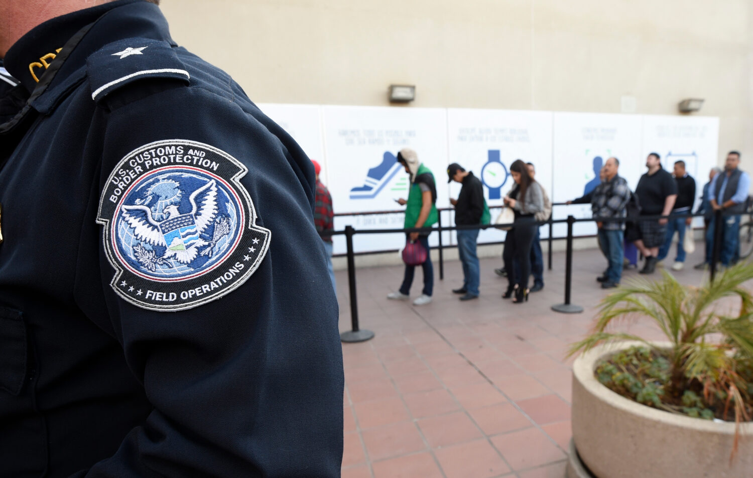 FILE - Pedestrians crossing from Mexico into the United States at the Otay Mesa Port of Entry wait ...