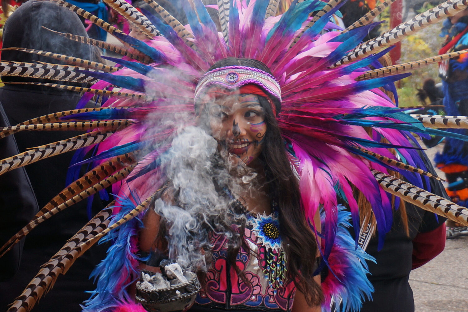 A member of an Aztec dance group holds incense during a commemoration of Día de Muertos (Day of th...