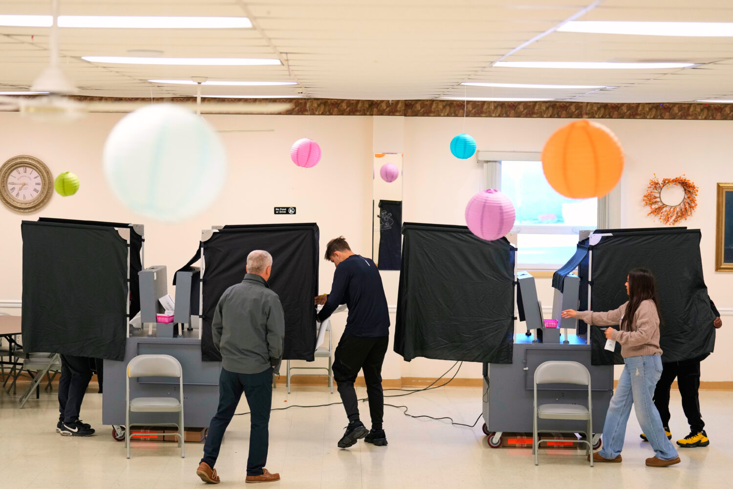 Poll workers help people get set up to vote at a polling site in Garfield, N.J., Tuesday, Nov. 4, 2...