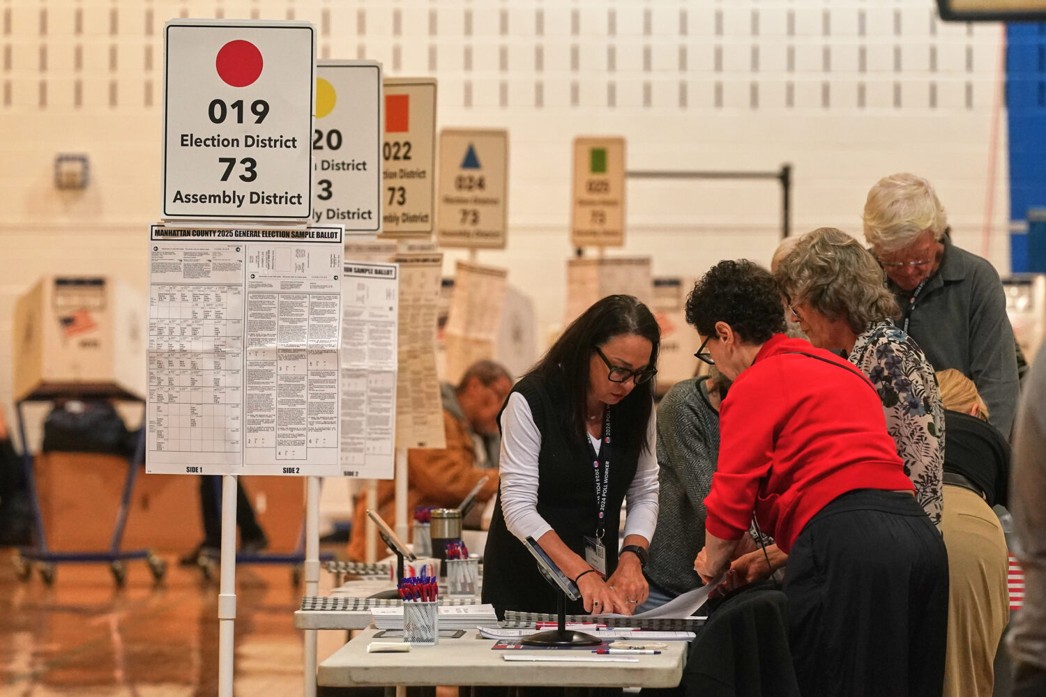 Workers prepare for voters at a poll site, in New York, Tuesday, Nov. 4, 2025. (AP Photo/Richard Dr...