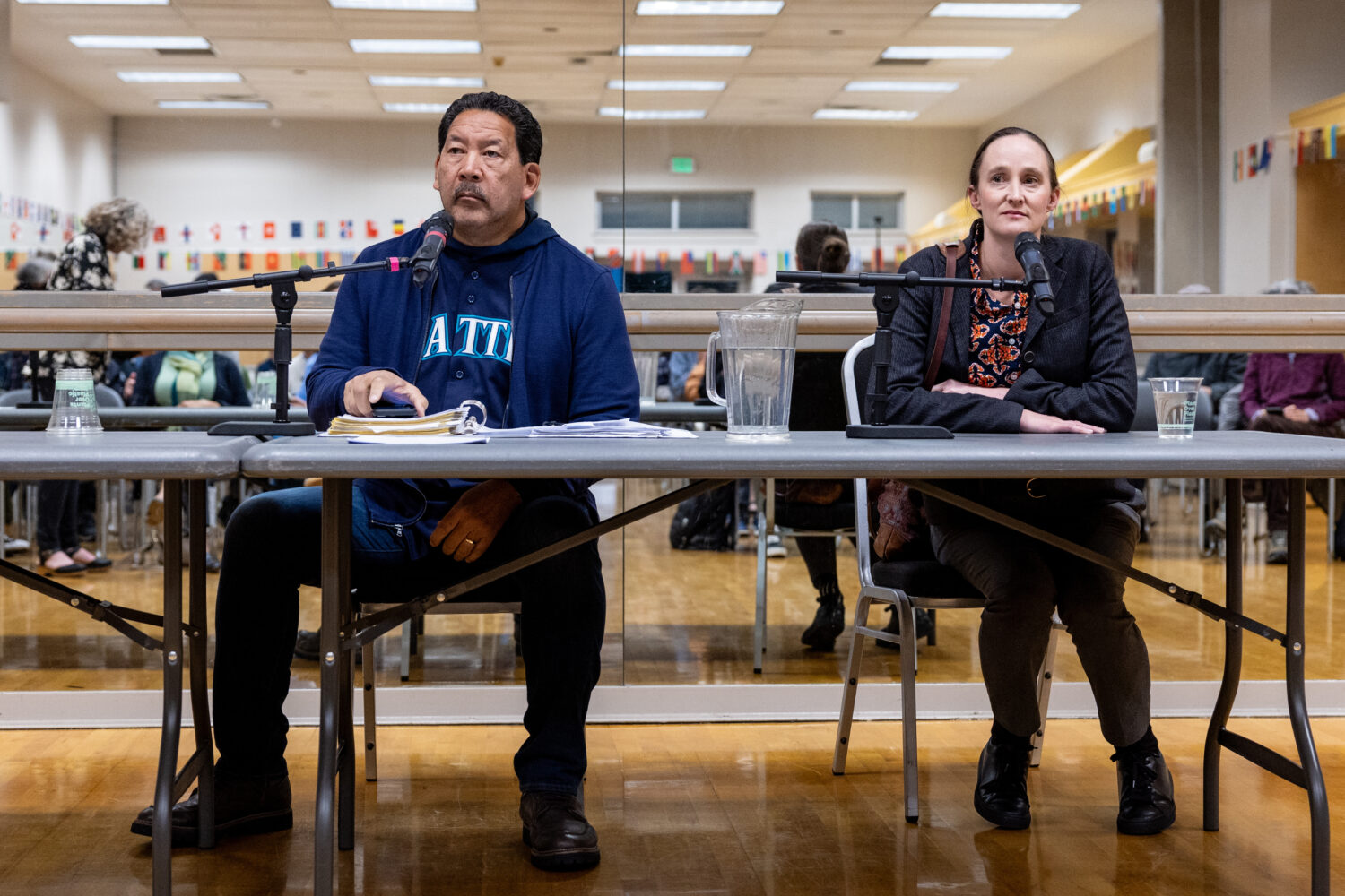 Seattle mayor Bruce Harrell, left, and mayoral candidate Katie Wilson, right, listen during a clima...