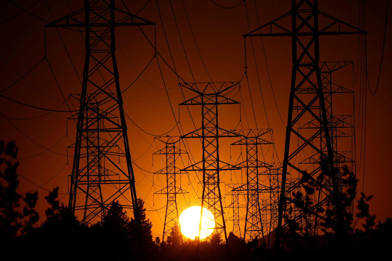FILE - The sun sets behind high tension power lines, Monday, Sept. 23, 2024, in the Porter Ranch se...