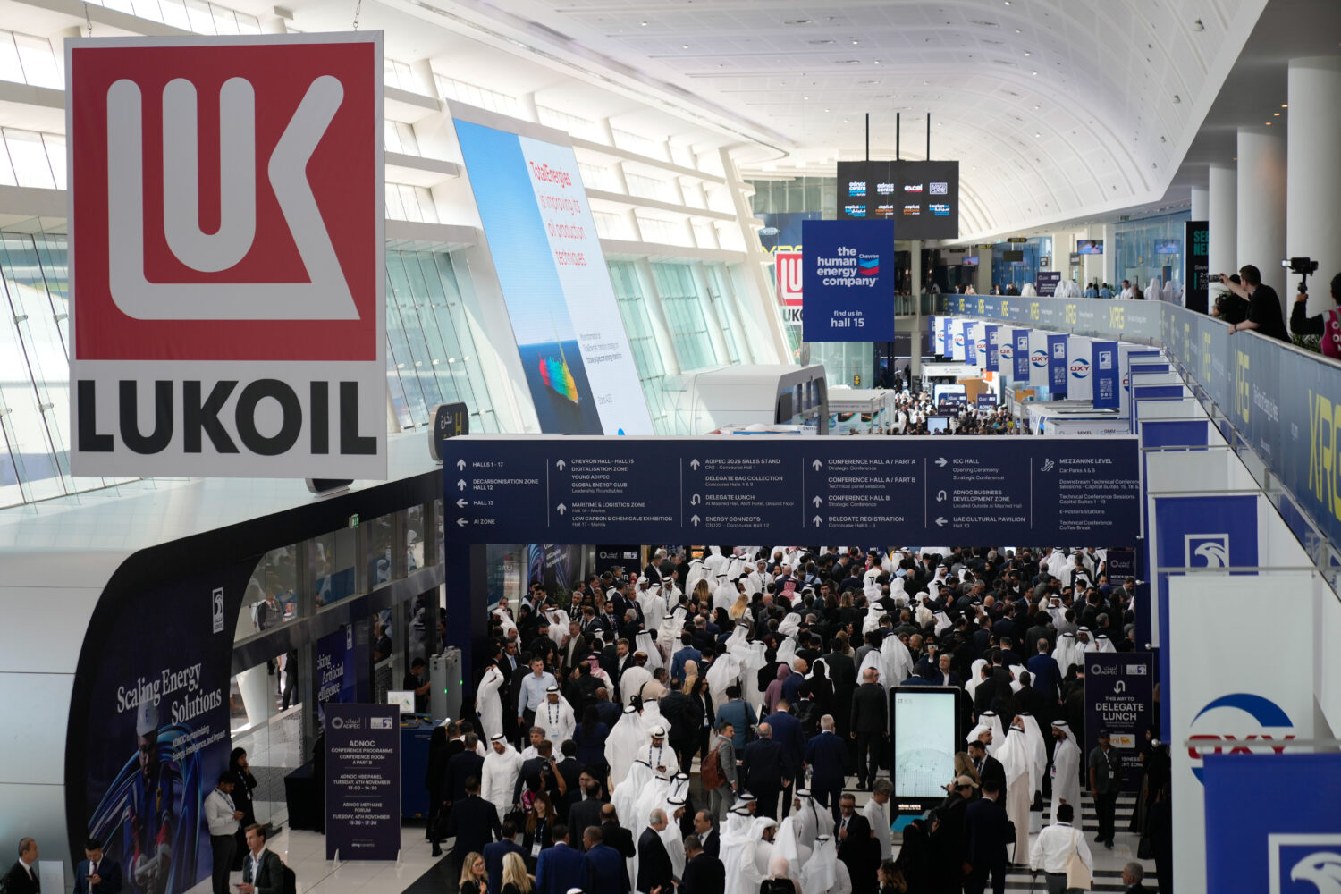 Logo of Russian oil company Lukoil hangs from the ceiling as visitors and delegates leave the hall ...