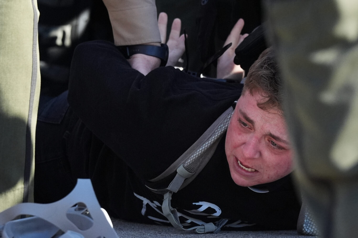 Illinois State police detain a protester outside an ICE processing facility in the Chicago suburb o...