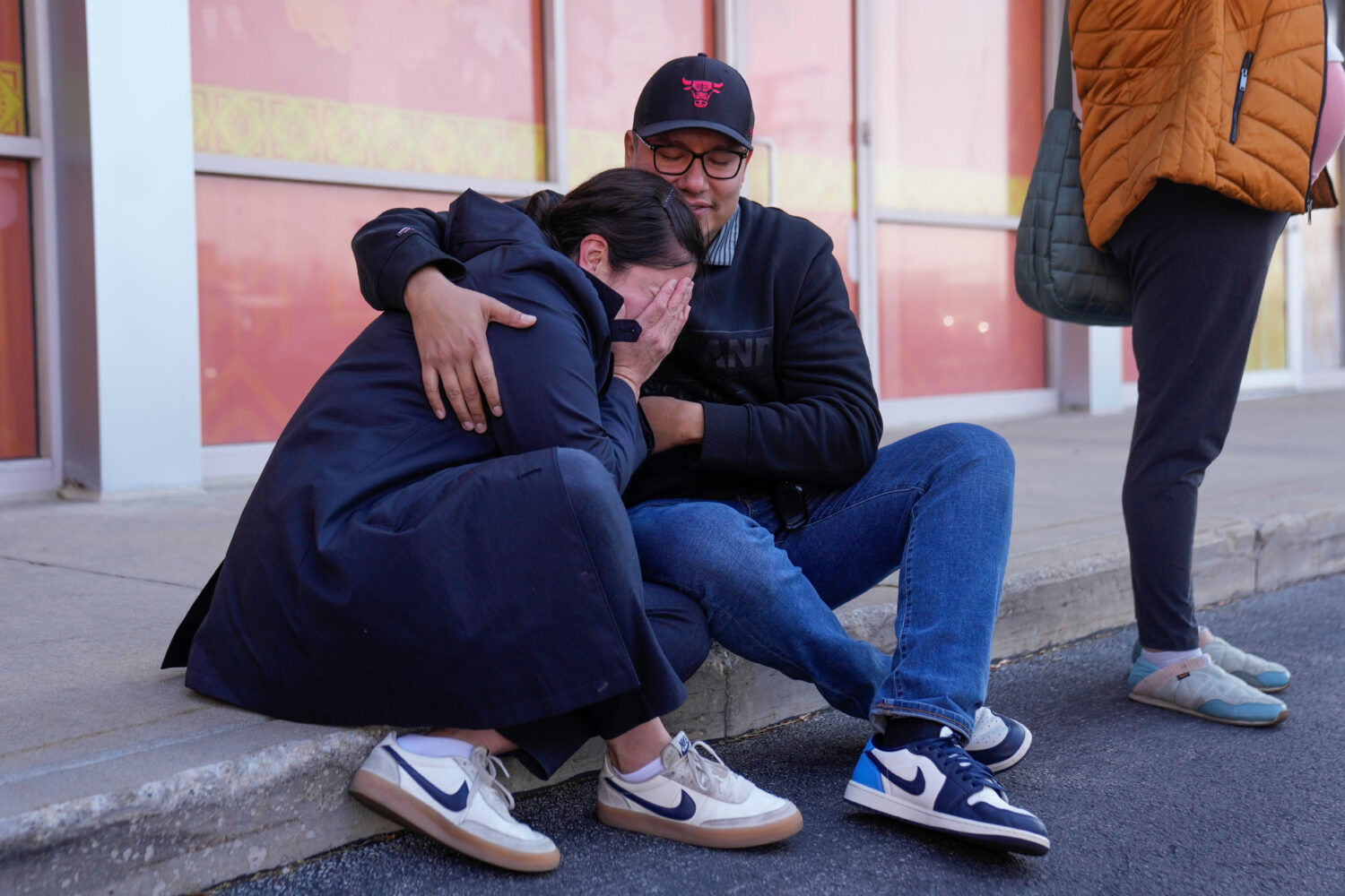 Maria Guzman, left, and Sergio Rocha, parents of young children, comfort each other outside of Rayi...