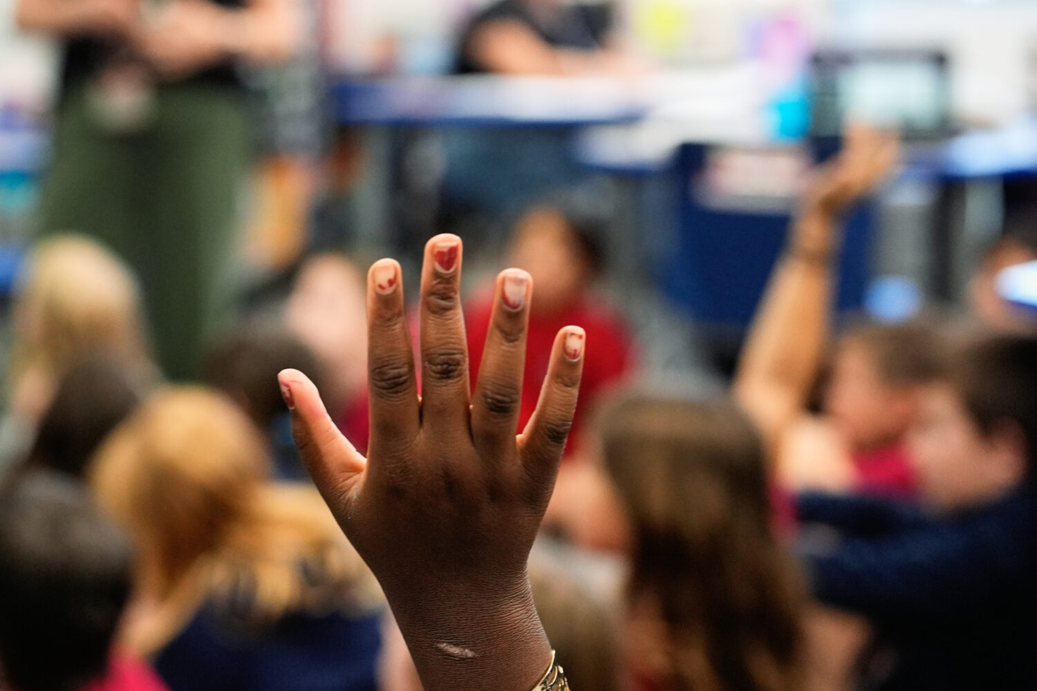 FILE - A student raises her hand at A.D. Henderson School in Boca Raton, Fla., April 16, 2024. (AP ...