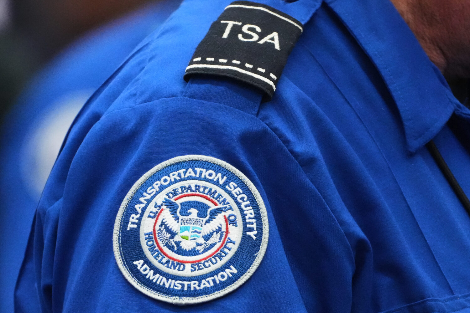 A TSA agent wears a Transportation Security Administration badge while checking identification at S...
