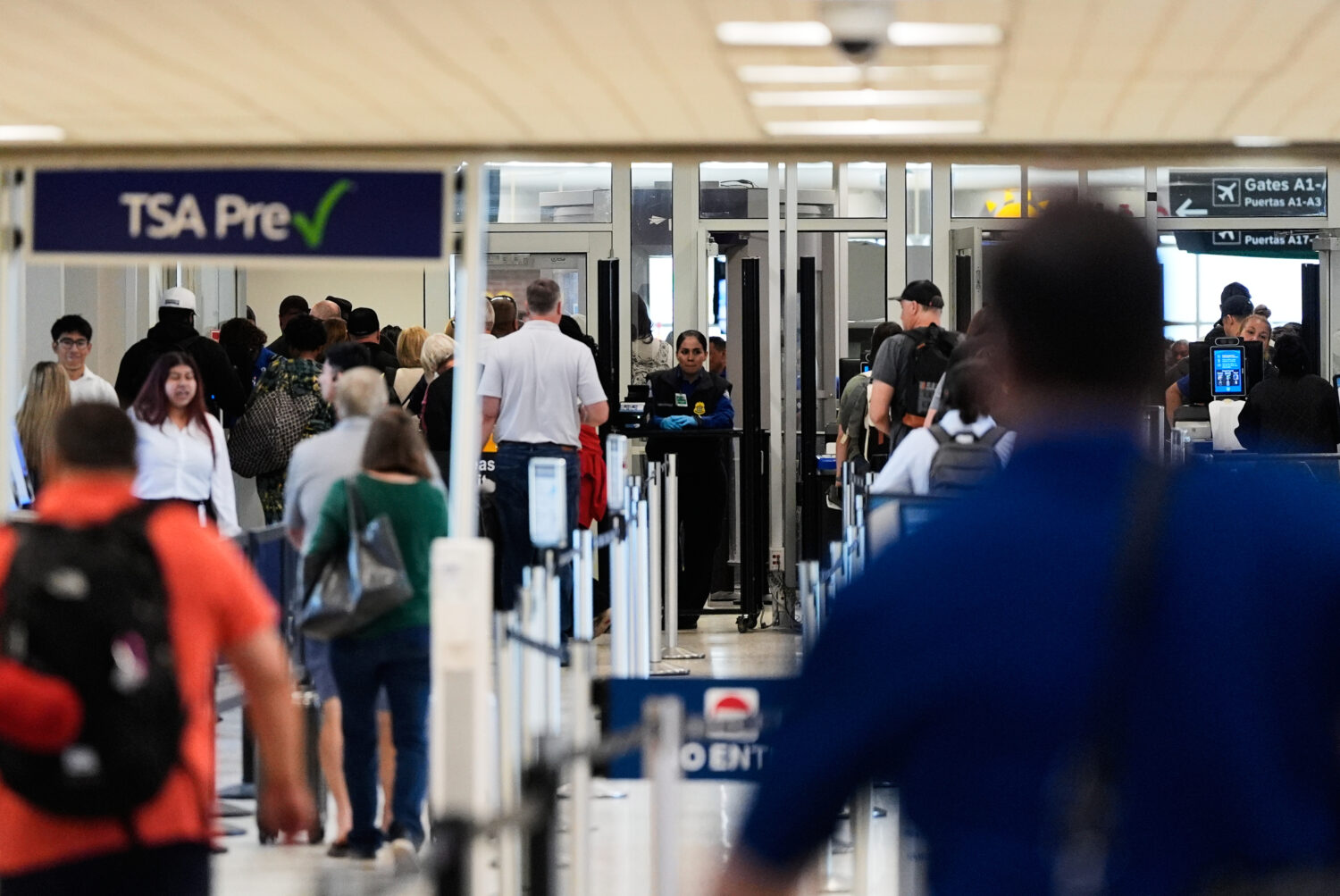Travelers stand in line at a security checkpoint at George Bush Intercontinental Airport on Friday,...