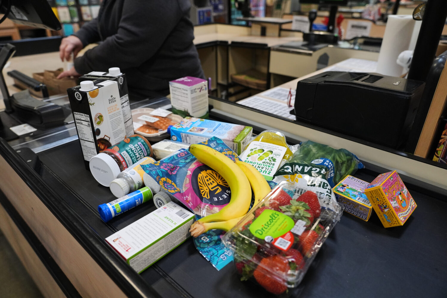 A cashier scans groceries, including produce, which is covered by the USDA Supplemental Nutrition A...