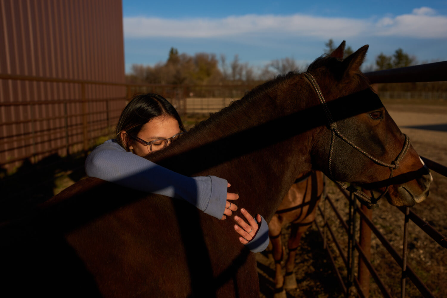 Sydney Diaz-Corral embraces a horse during a class in the Nueta Hidatsa Sahnish College equine stud...