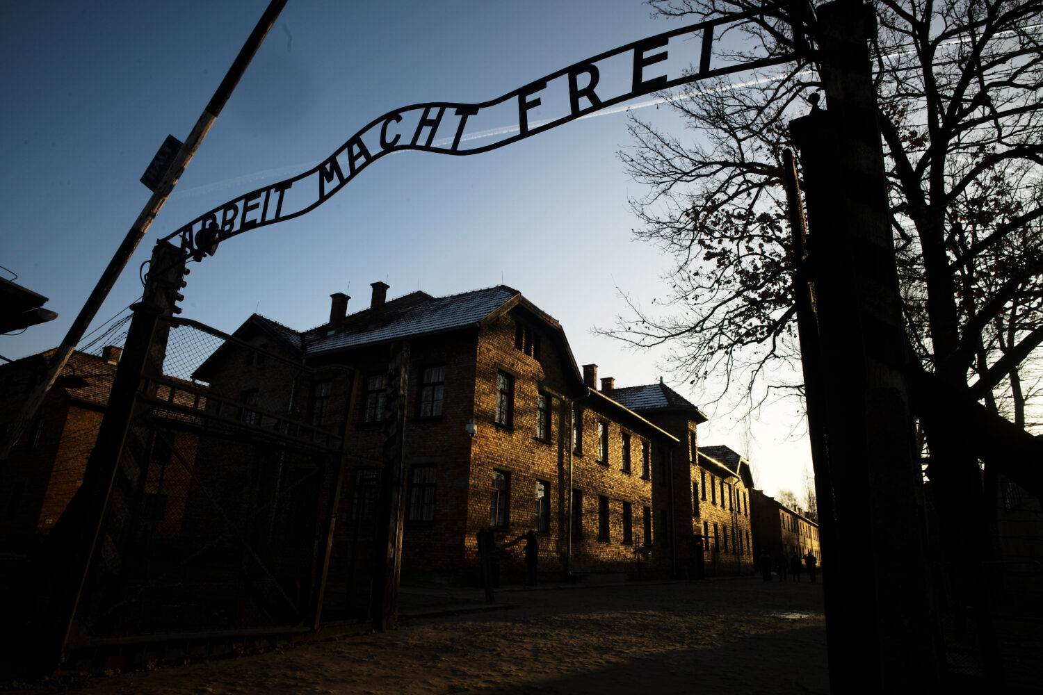 FILE - The sun lights the buildings behind the entrance of the former Nazi death camp Auschwitz-Bir...