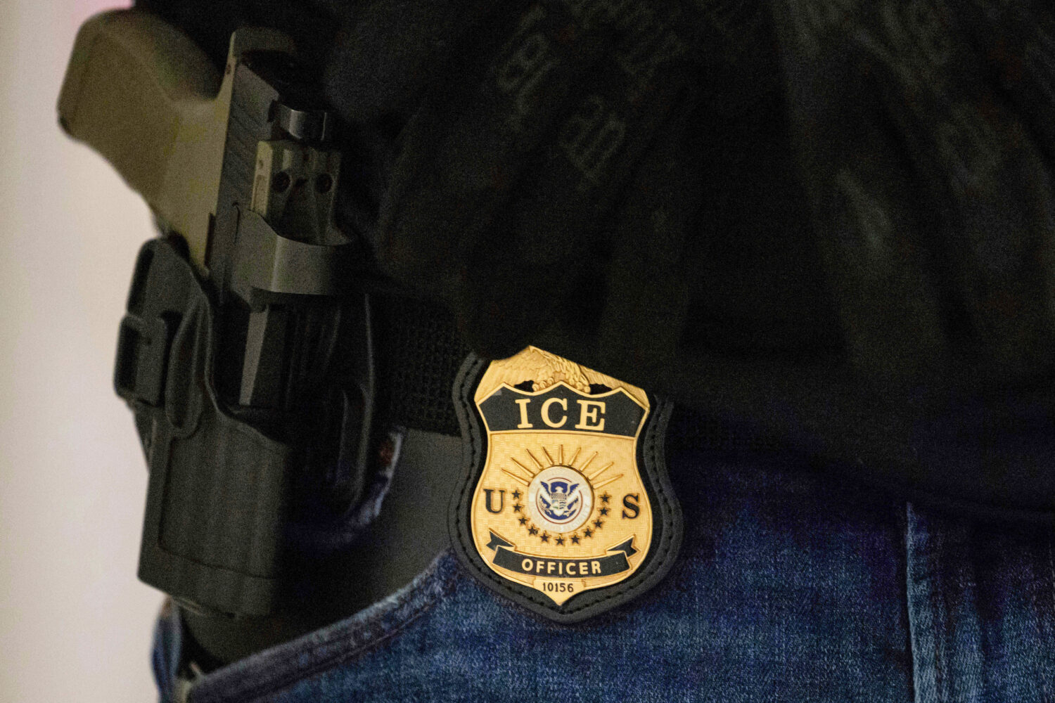 FILE - A federal agent wears an Immigration and Customs Enforcement badge at the immigration court ...