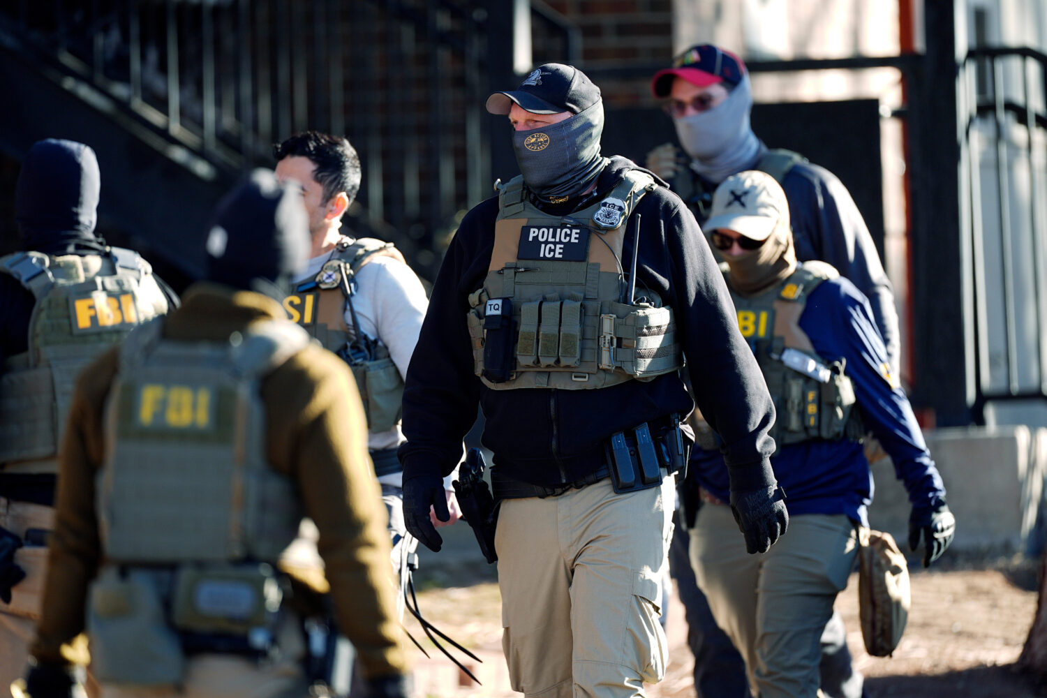 FILE - Law officials spread out through an apartment complex during a raid, Feb. 5, 2025, in east D...