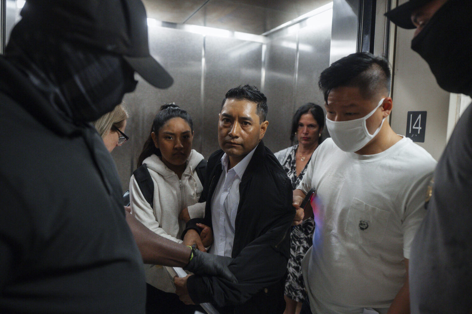 Immigration and Customs Enforcement agents pull a man out of an elevator as he and his daughter att...