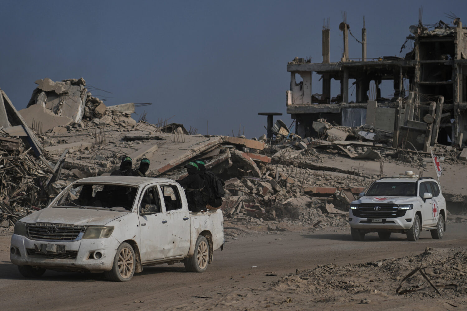 Hamas militants accompanied by members of the International Committee of the Red Cross (ICRC) head ...