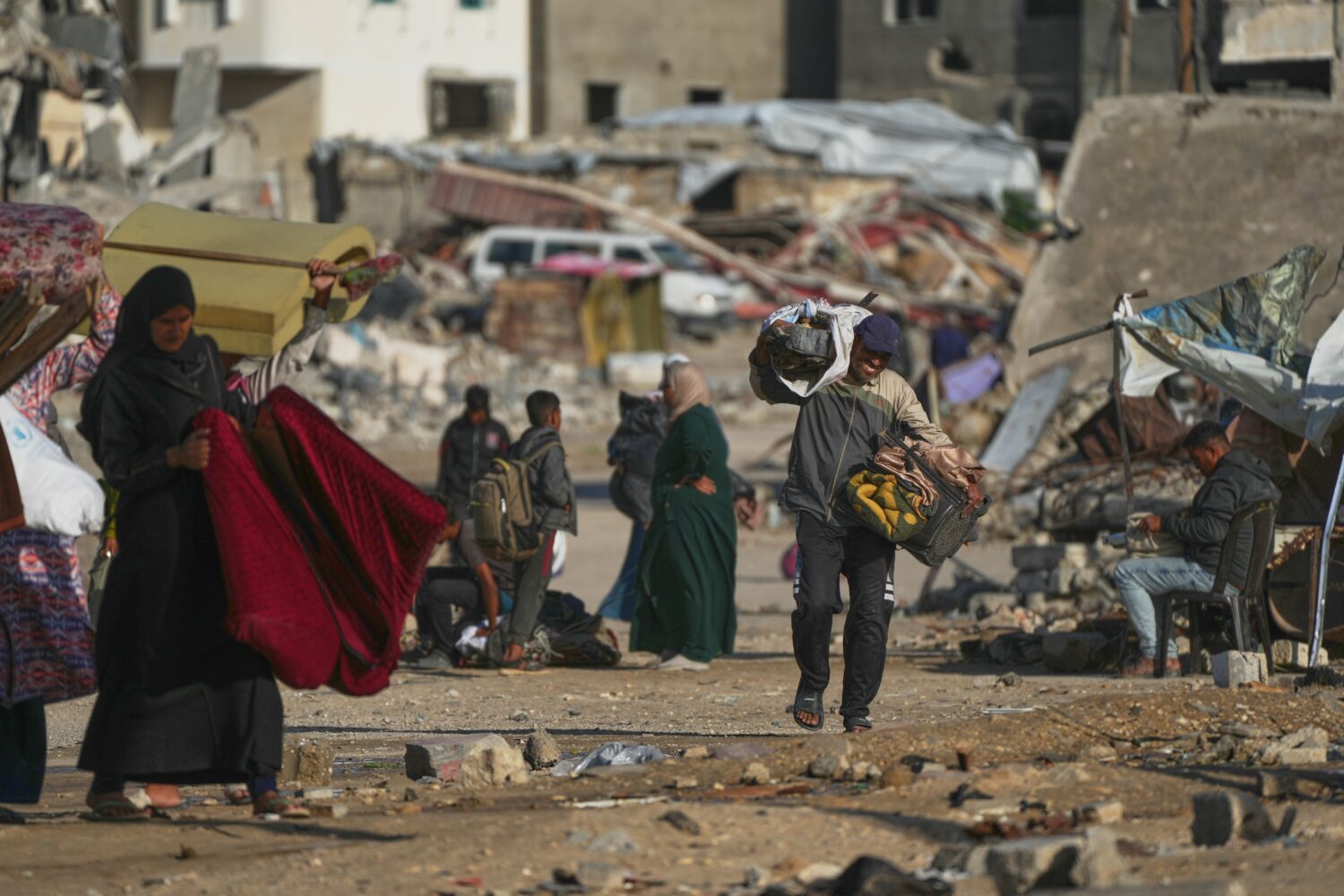 A man Palestinian man carries bags of firewood after collecting them from the rubbish in Khan Youni...
