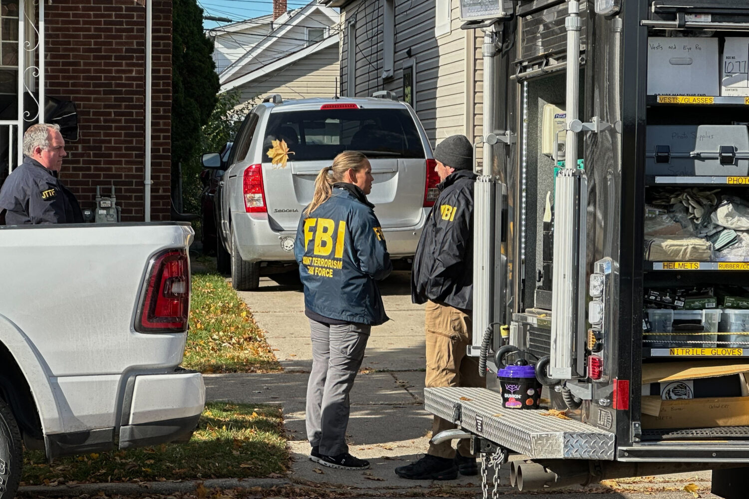 FBI agents gather outside a home in a Dearborn, Mich., neighborhood on Friday, Oct. 31, 2025. (AP P...