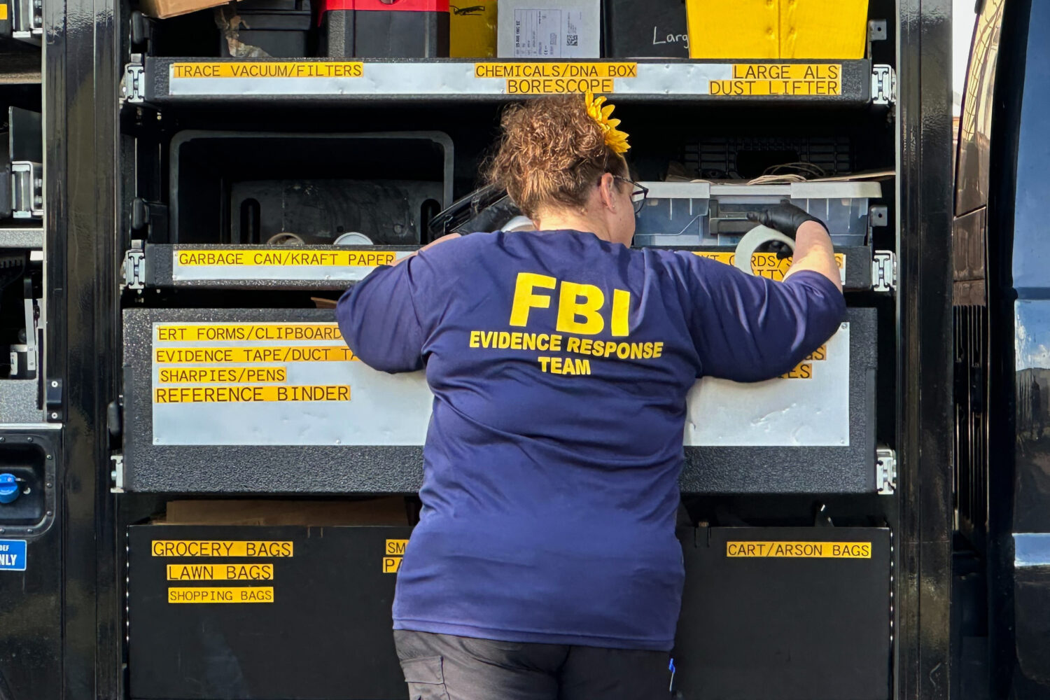 An FBI agent stands by an Evidence Response Team truck outside a home in a Dearborn, Mich., neighbo...