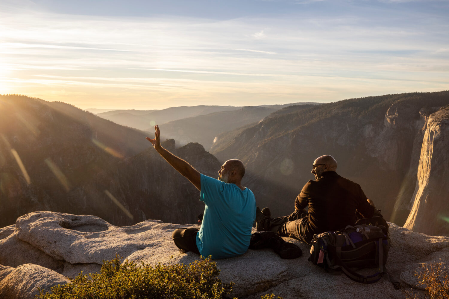 FILE - Visitors watch a sunset on rock ledge near Taft Point in Yosemite National Park, Calif., Oct...