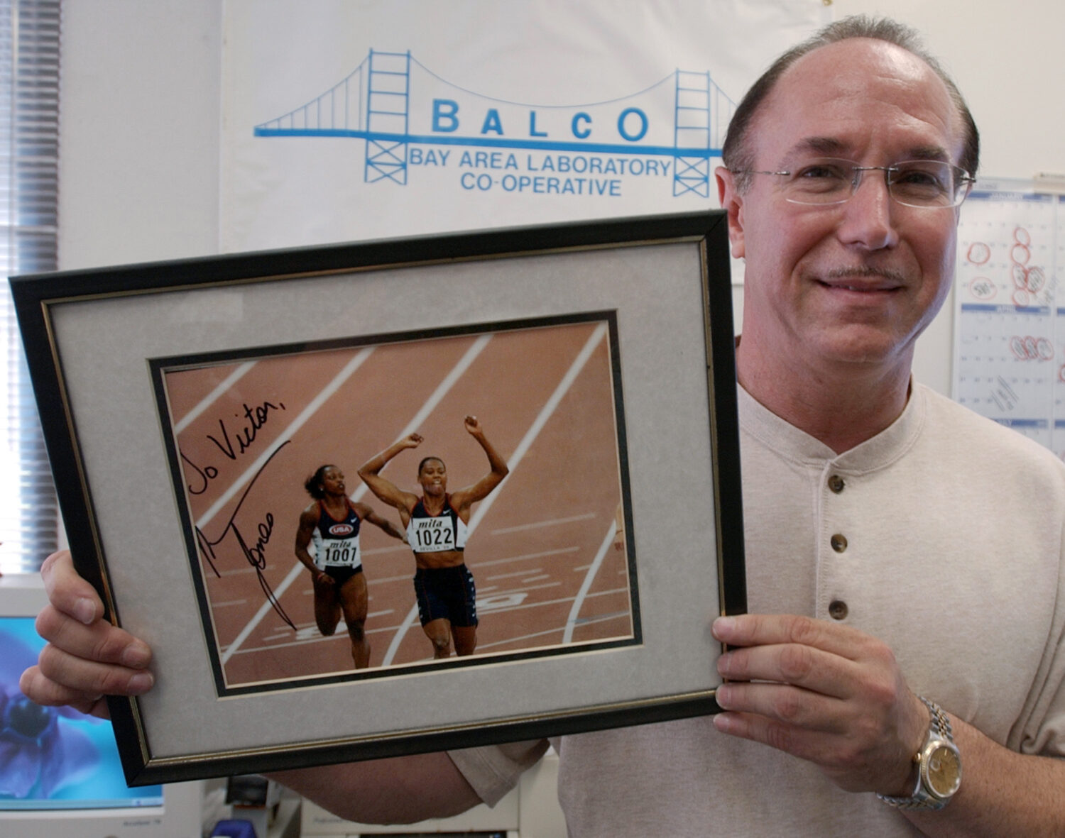 FILE - BALCO founder Victor Conte holds up an autographed photo addressed to Conte of track star Ma...