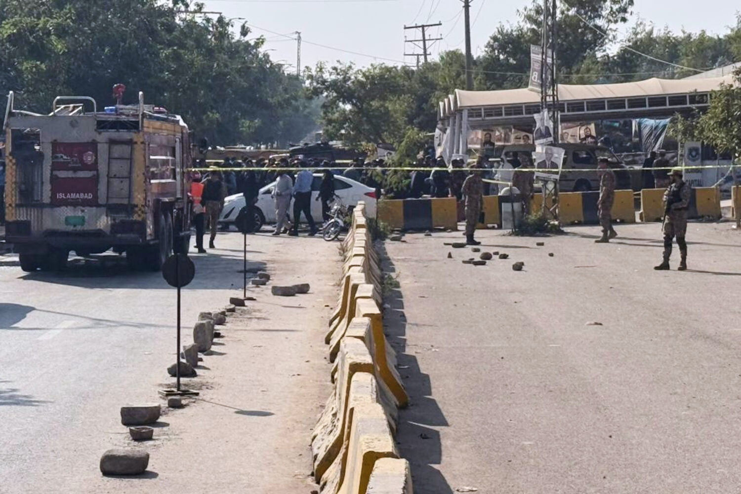 Pakistani security officials stand guard after a powerful car bomb exploded outside a district cour...