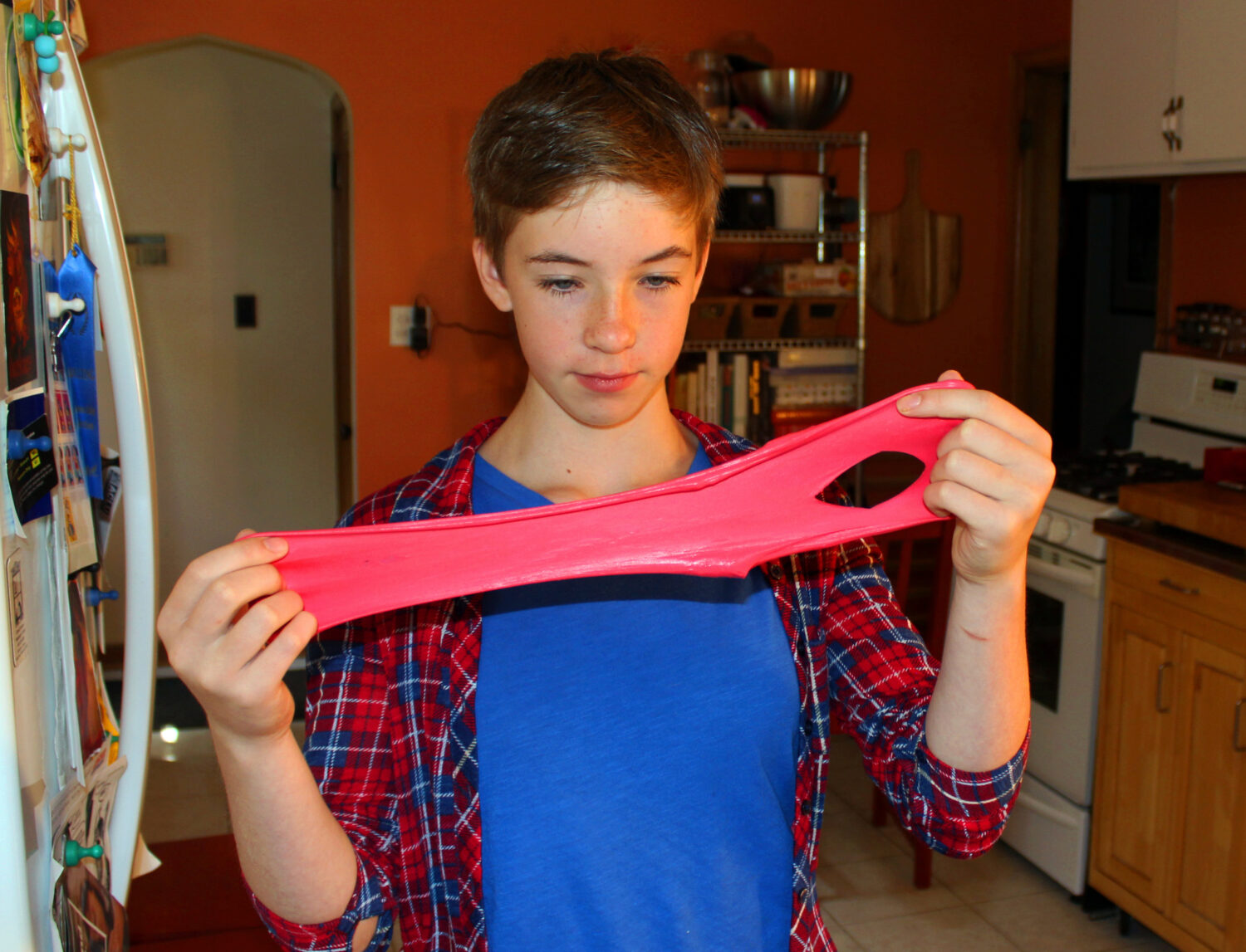 FILE - Astrid Rubens demonstrates the elasticity of homemade slime in her kitchen in St. Paul, Minn...