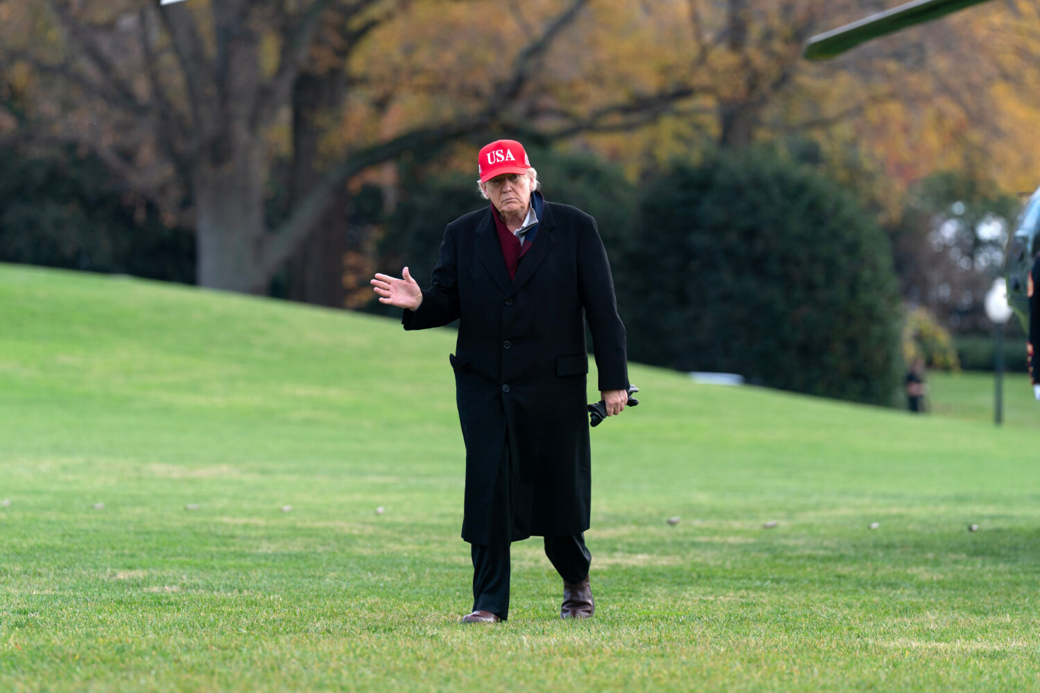 President Donald Trump waves to the media as he walks in the South Lawn upon his arrival to the Whi...