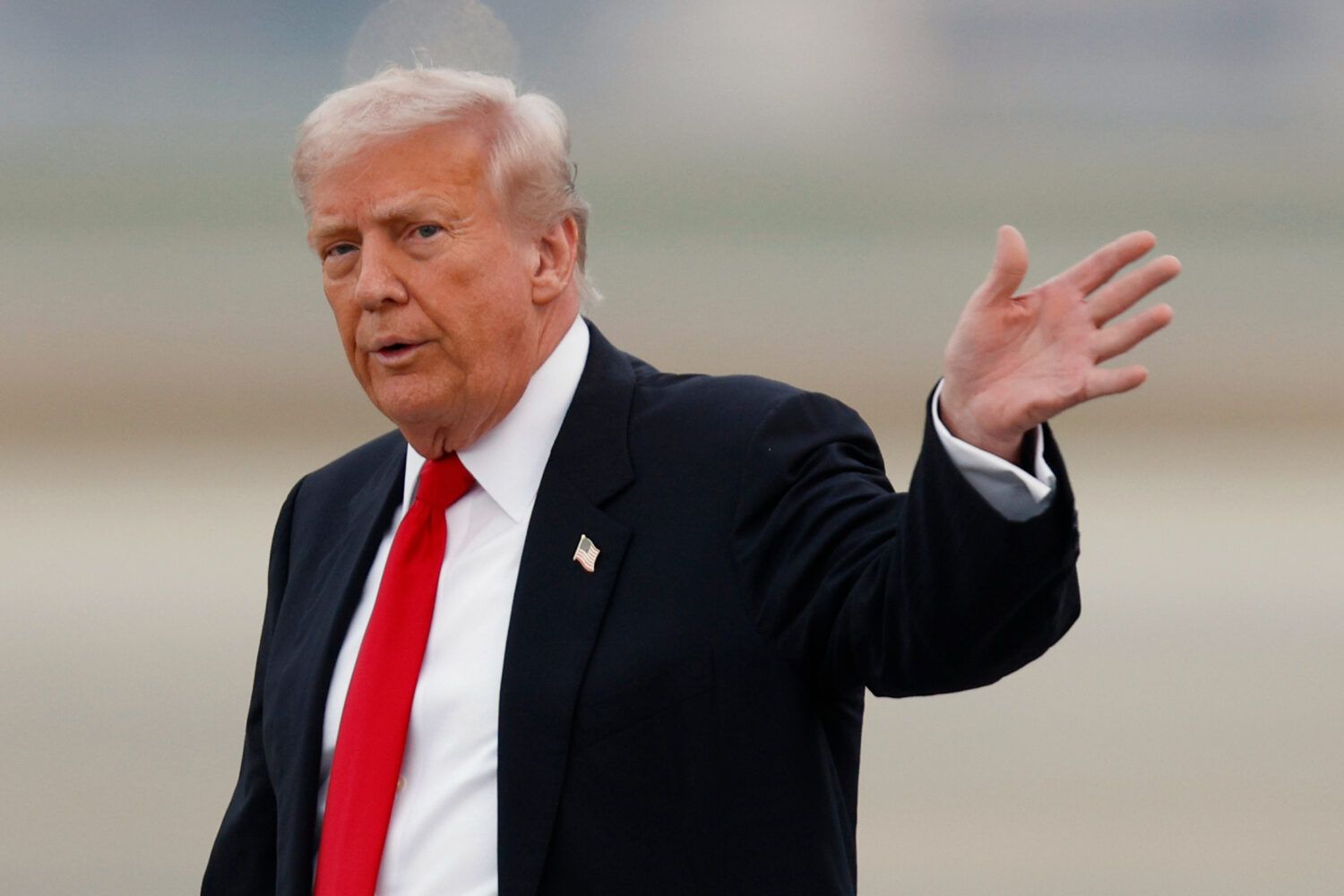 President Donald Trump waves after speaking to the media upon his arrival at Joint Base Andrews, Md...