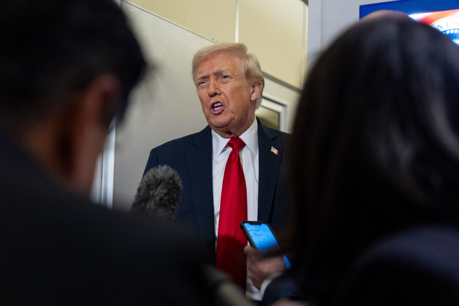 President Donald Trump speaks with reporters while in flight on Air Force One from Joint Base Andre...