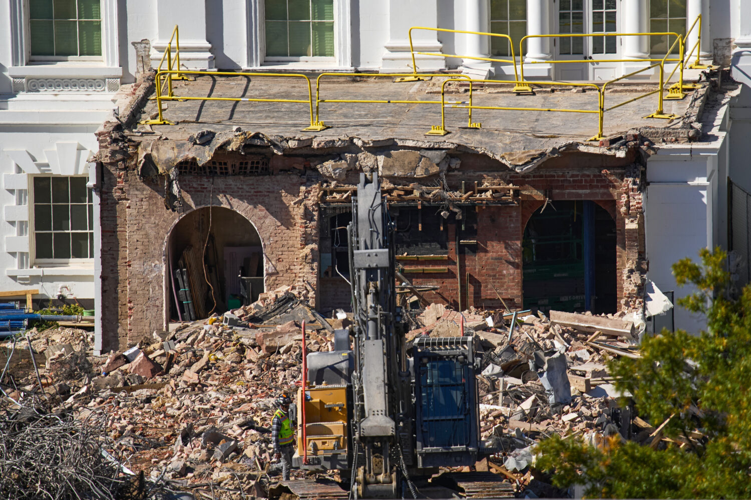 FILE - A worker walks among debris from a largely demolished part of the East Wing of the White Hou...