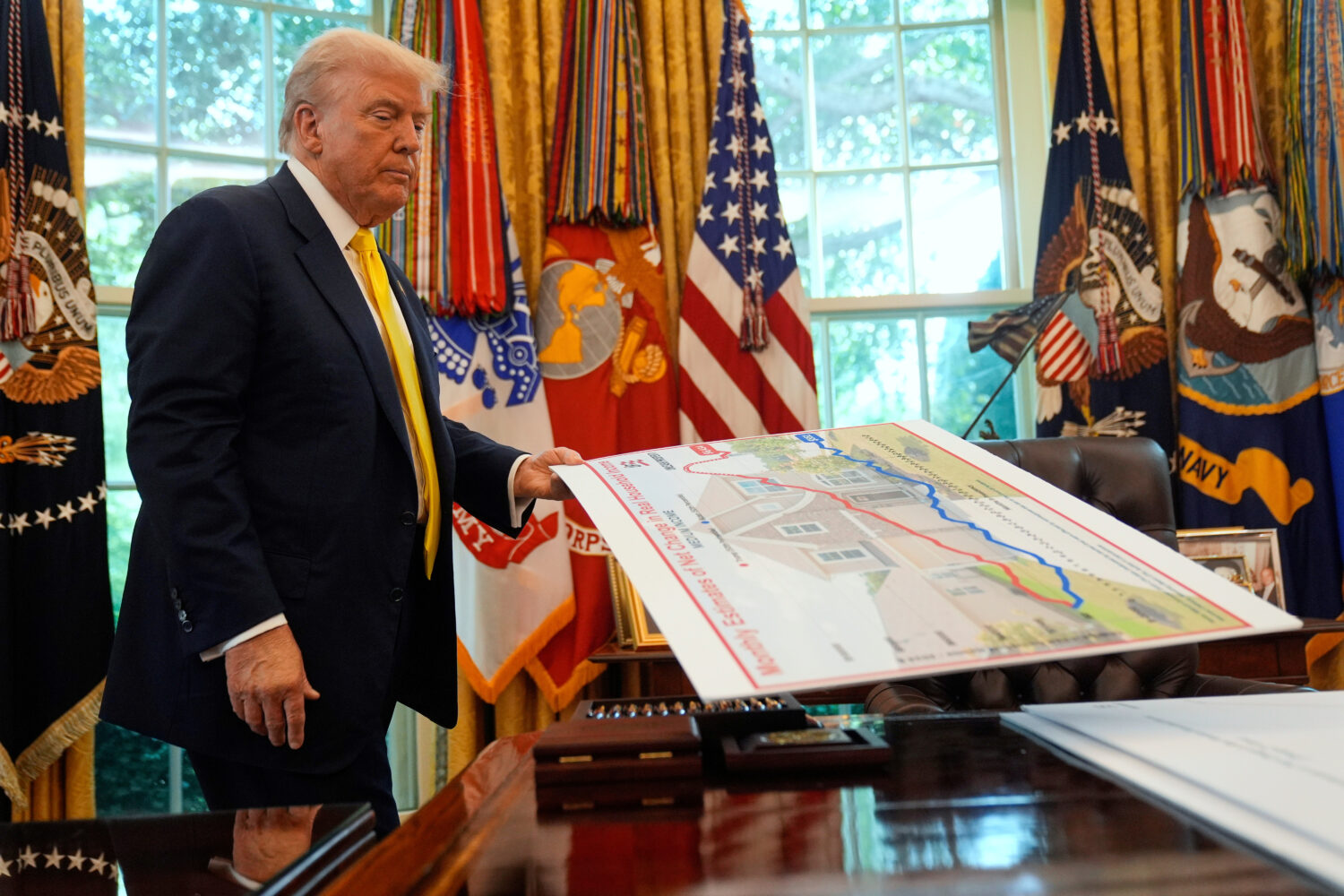 FILE - President Donald Trump holds a chart as he discusses the economy in the Oval Office of the W...