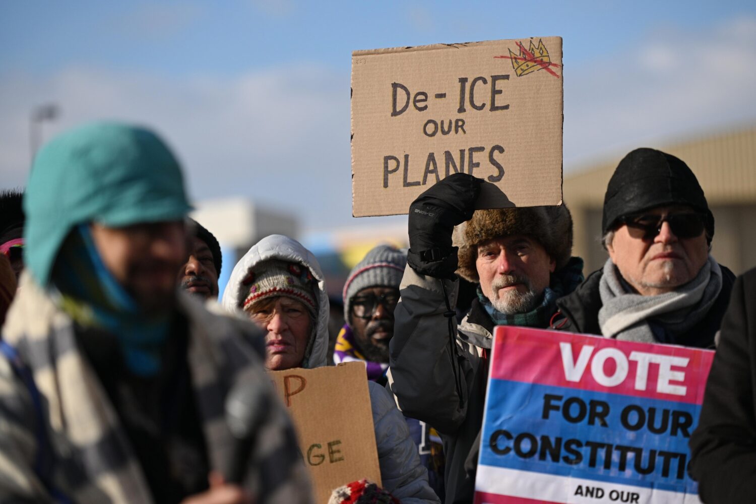 Protesters gather at a rally for immigrants and workers outside Signature Aviation near the Minneap...