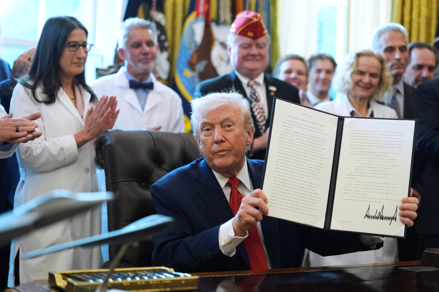 President Donald Trump displays an executive order reclassifying marijuana as a less dangerous drug...