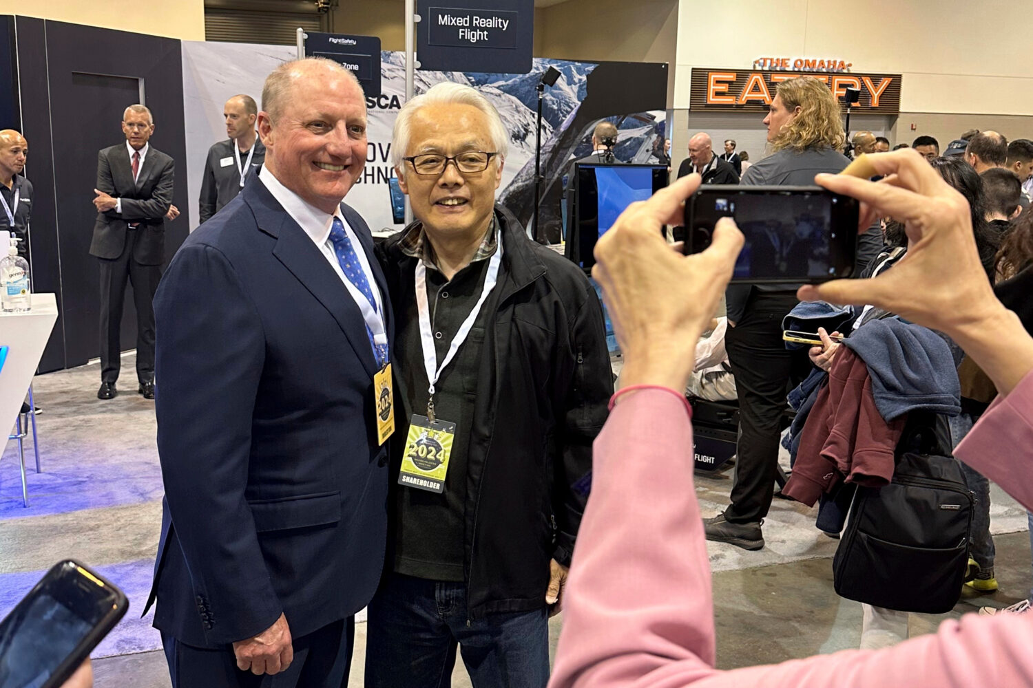 FILE - Berkshire Hathaway Vice Chairman Greg Abel poses for pictures with shareholders while tourin...