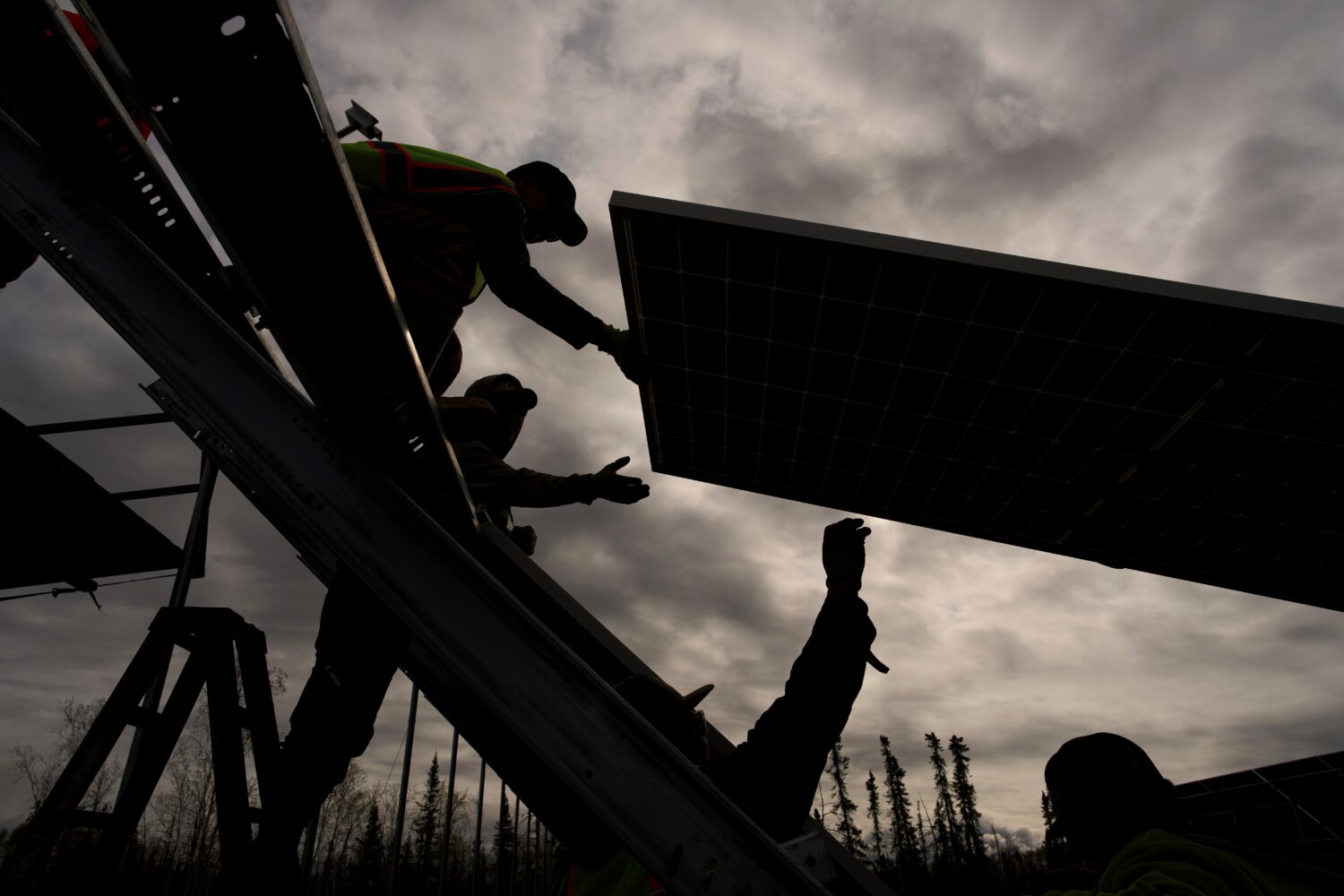 FILE - Workers install panels at a solar project May 21, 2025, in Galena, Alaska. (AP Photo/John Lo...