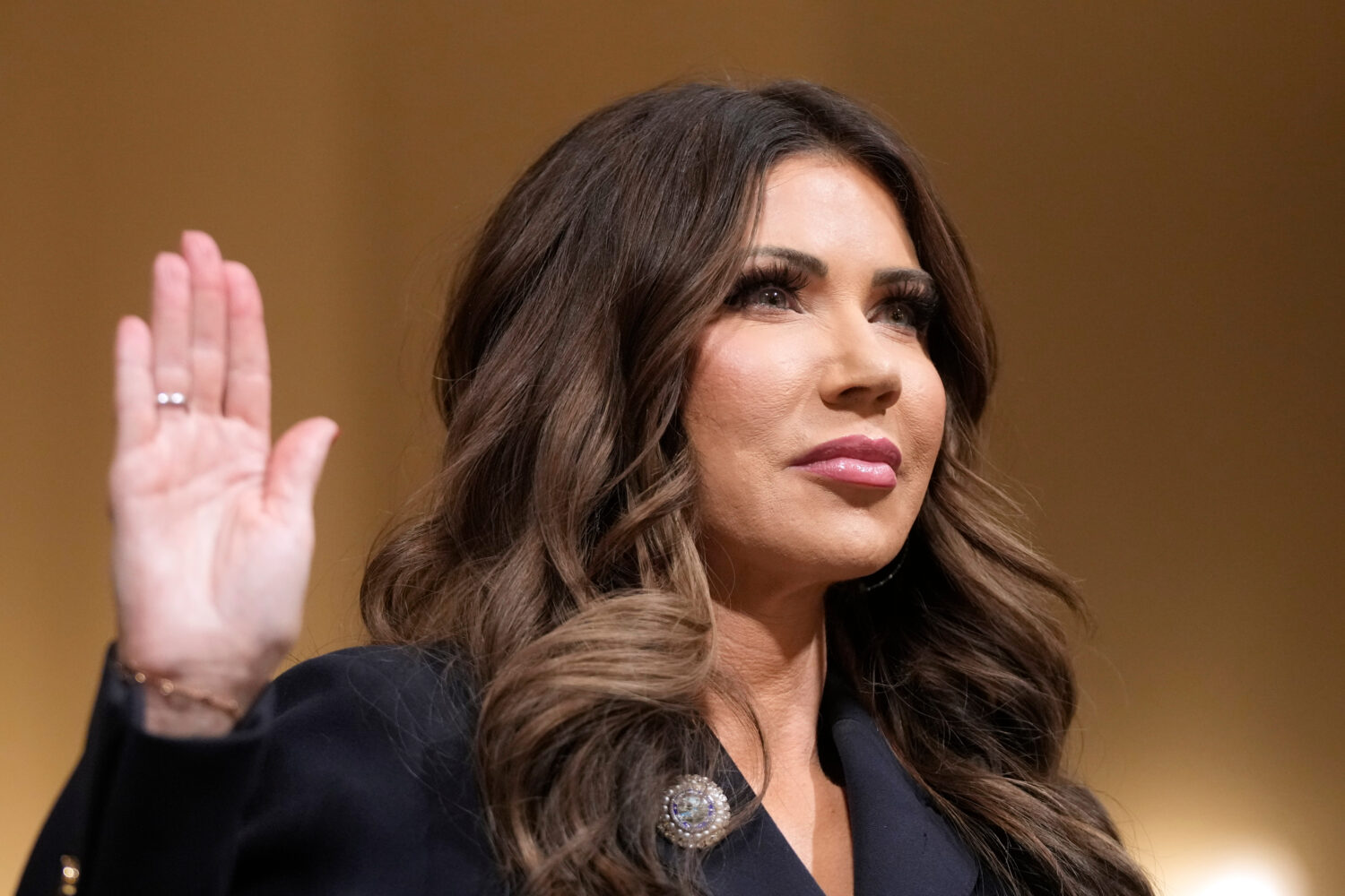 Homeland Security Secretary Kristi Noem raise her arm before the House Committee on Homeland Securi...