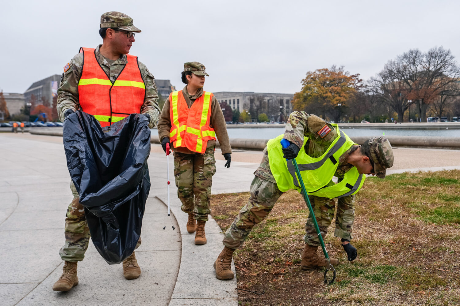 Members of the District of Columbia National Guard pick up trash by the Capitol reflecting pool, Fr...