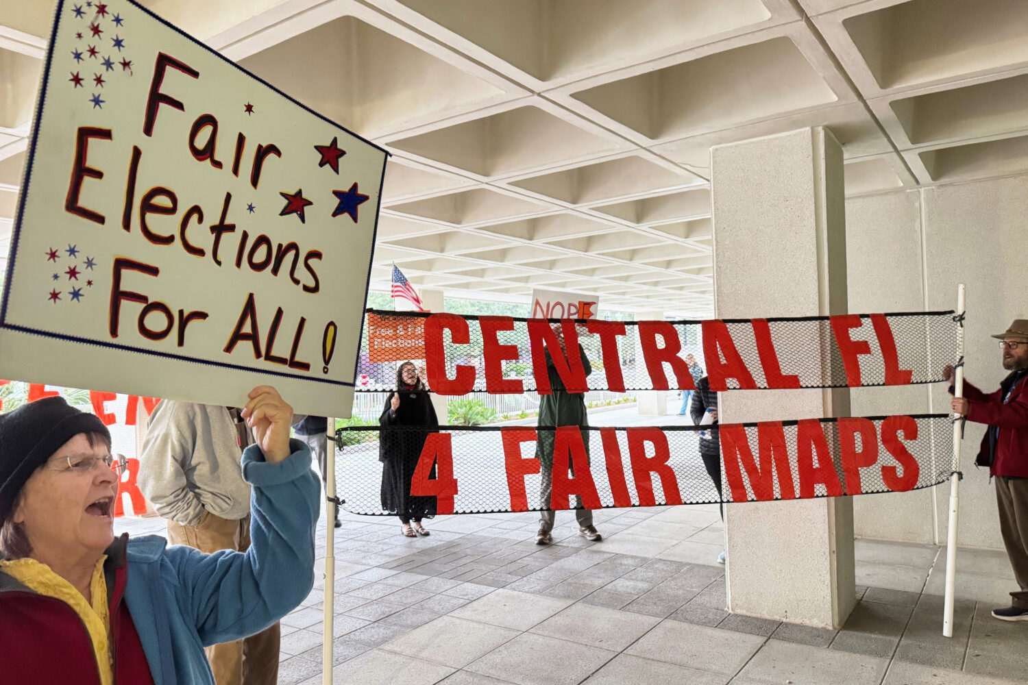 Protestors opposed to mid-decade redistricting wave signs outside of Florida’s Capitol building i...