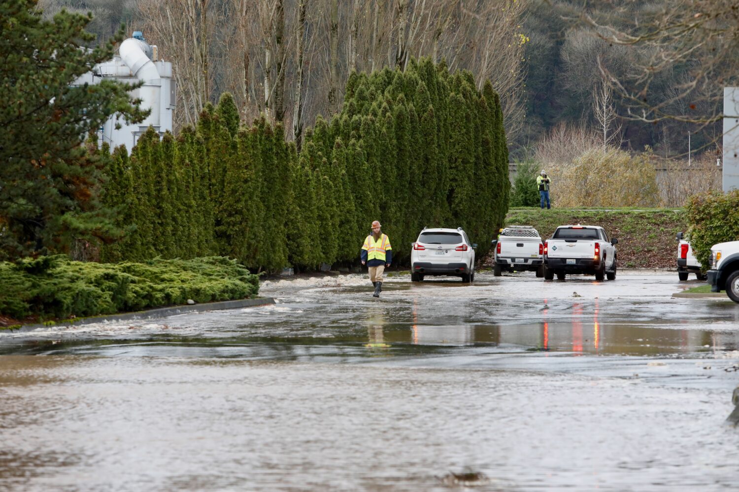 A response team crew member walks by standing water from a levee breach on the Green River in Tukwi...