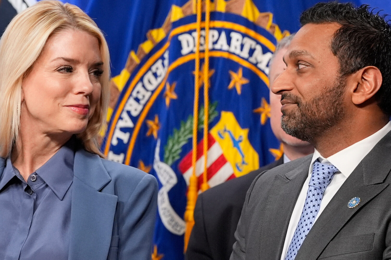 Attorney General Pam Bondi and FBI Director Kash Patel look at each other during a news conference ...