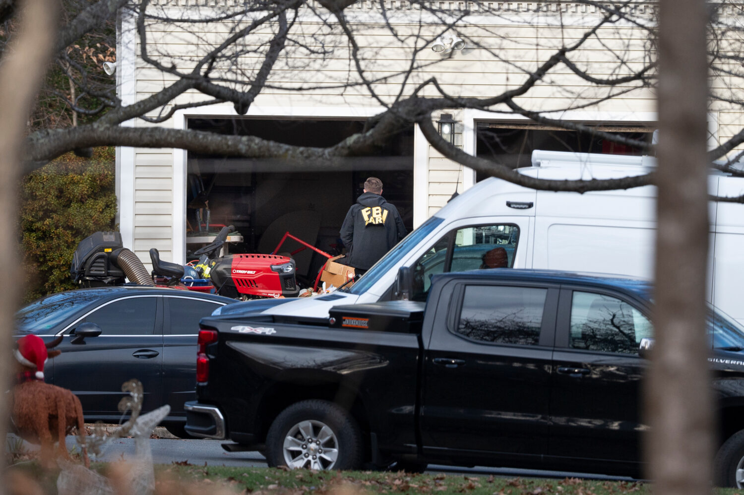 A FBI agent enters the garage of the house where they made an arrest, in Woodbridge, Va., Thursday,...