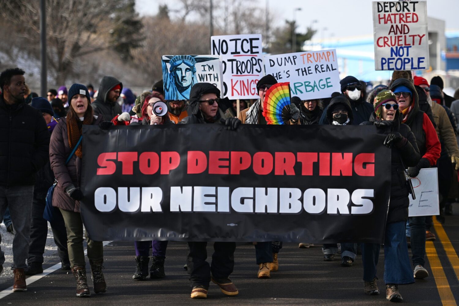 Protesters gather at a rally for immigrant and worker outside Signature Aviation near the Minneapol...