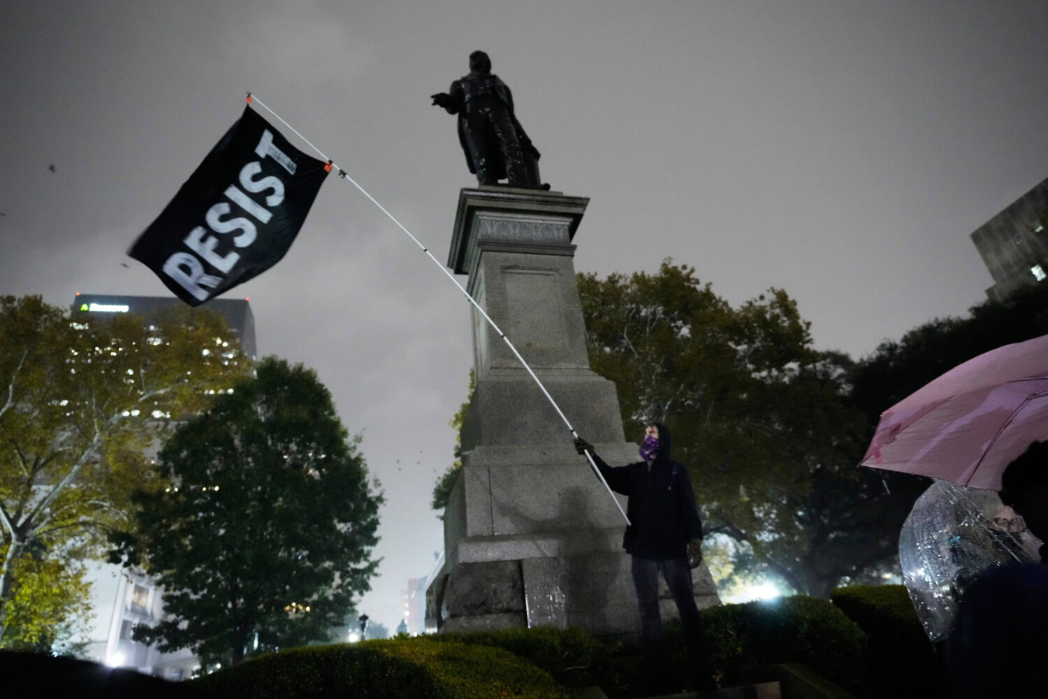 A protestor waves a flag in a pouring rain during a demonstration against an impending Customs and ...