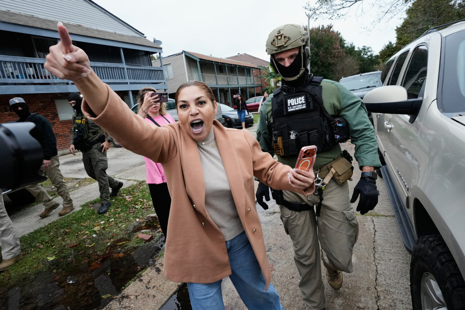 FILE - Wilma Fuentes yells at Customs and Border Patrol commander Gregory Bovino and some of his ag...