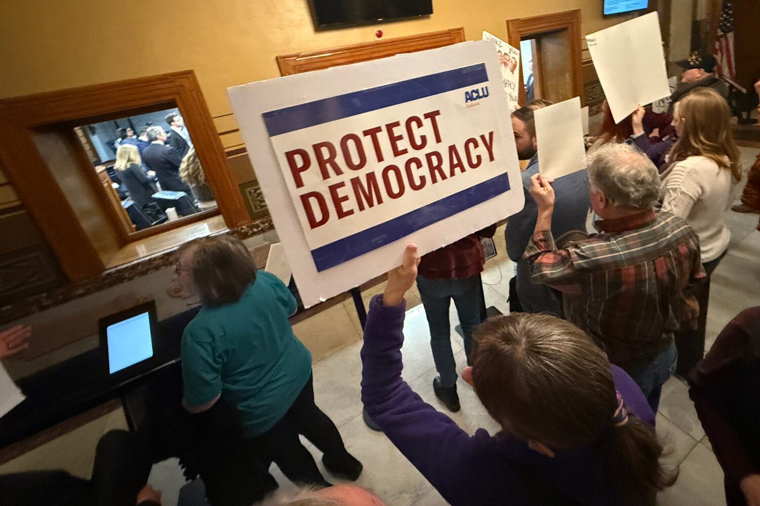 Protesters gather outside the Senate chamber at the Statehouse as senators meet during a special se...